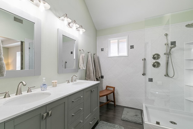 bathroom featuring lofted ceiling, wood-type flooring, a shower with door, and vanity