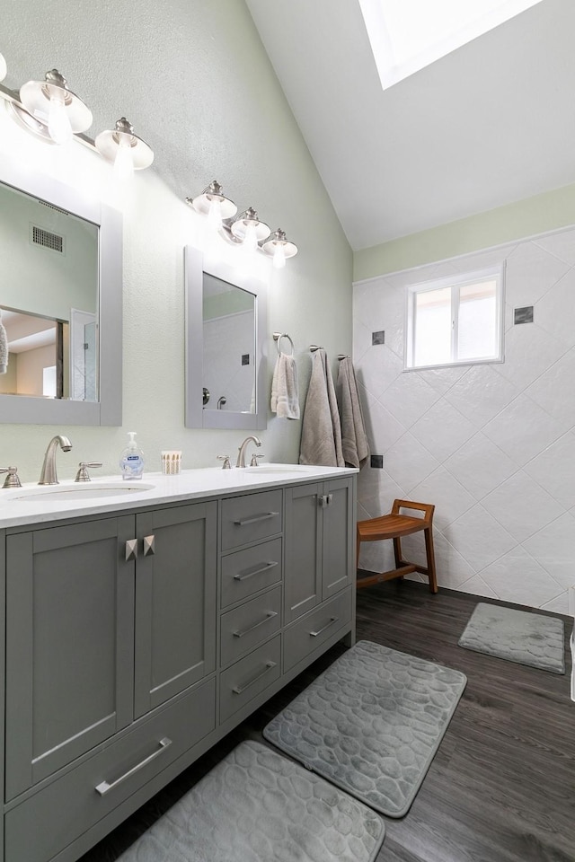 bathroom with vanity, vaulted ceiling, and hardwood / wood-style flooring