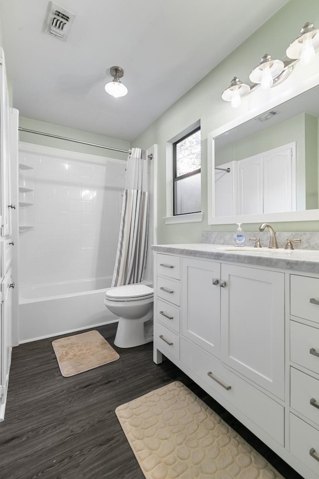 full bathroom with wood-type flooring, vanity, shower / tub combo, and toilet