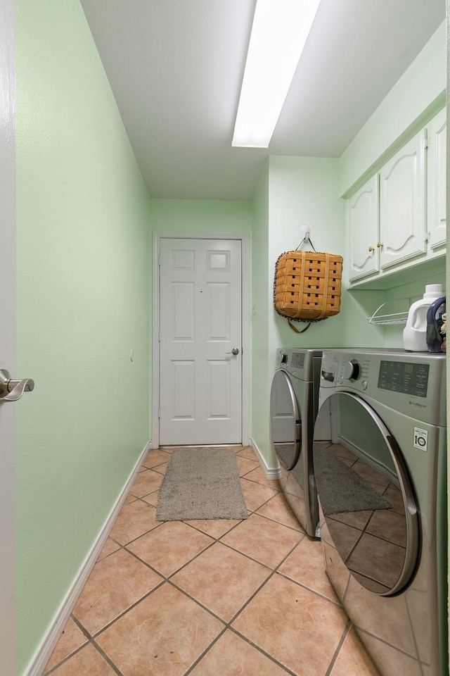 clothes washing area featuring light tile patterned flooring, cabinets, and independent washer and dryer