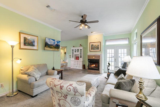 carpeted living room with ceiling fan, crown molding, and french doors