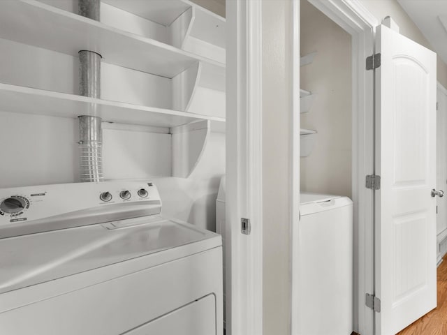 laundry area with wood-type flooring and washing machine and clothes dryer