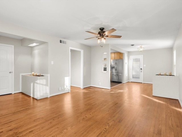 unfurnished living room with light wood-type flooring and ceiling fan