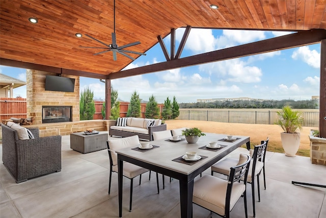 view of patio with an outdoor living space with a fireplace and ceiling fan