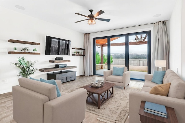 living room with ceiling fan and light wood-type flooring