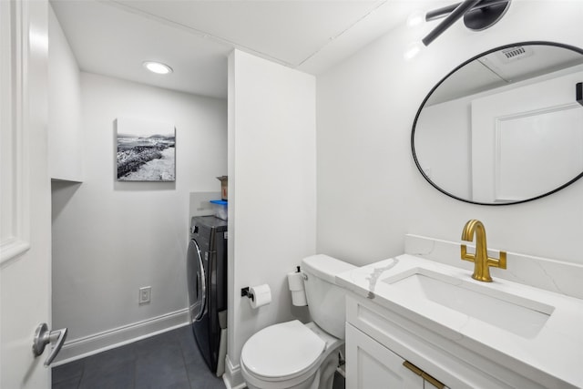 bathroom featuring toilet, vanity, and separate washer and dryer