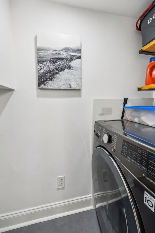 laundry room featuring dark tile patterned floors and washer / clothes dryer