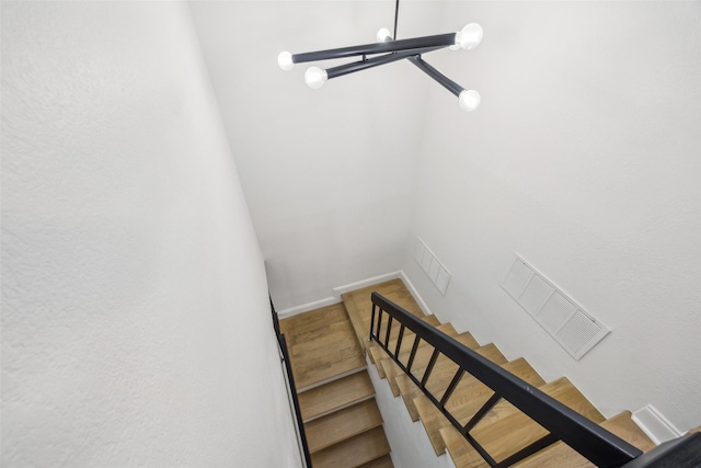 staircase with an inviting chandelier