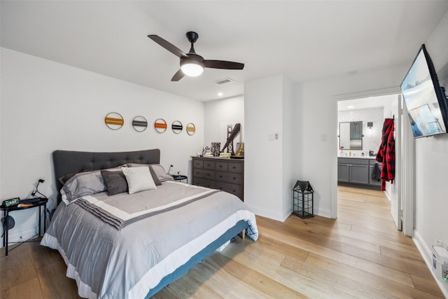 bedroom with ceiling fan, light hardwood / wood-style flooring, and ensuite bath