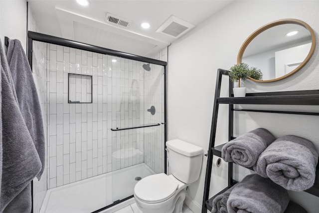 bathroom with toilet and a shower with door