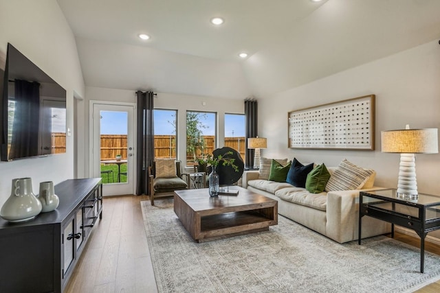 living room with light hardwood / wood-style floors and lofted ceiling