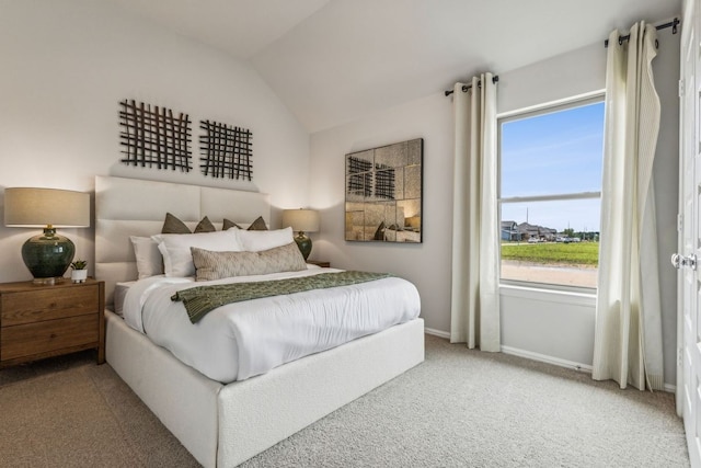 bedroom featuring carpet flooring, vaulted ceiling, and multiple windows