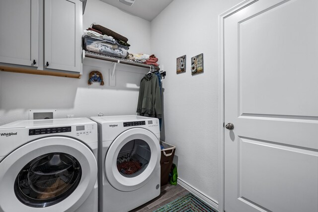 washroom with cabinets, washing machine and dryer, and dark wood-type flooring