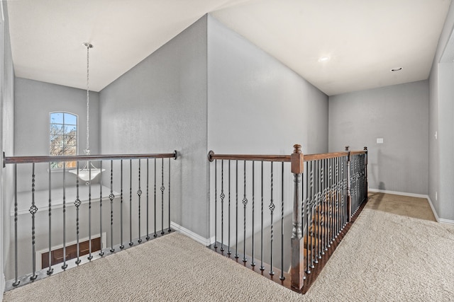 hallway with carpet flooring and lofted ceiling