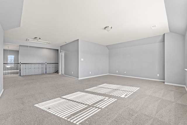 unfurnished room with light carpet and vaulted ceiling