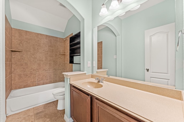 full bathroom featuring tile patterned flooring, vaulted ceiling, toilet, vanity, and tiled shower / bath