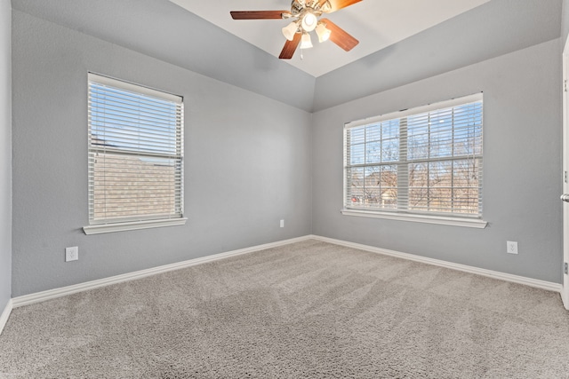 carpeted spare room with ceiling fan and vaulted ceiling