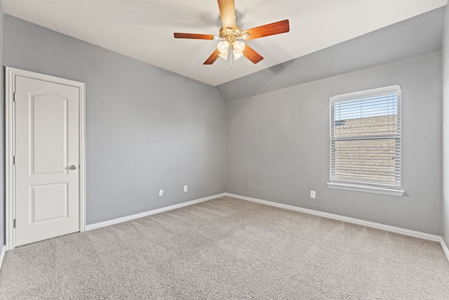 spare room with carpet floors, vaulted ceiling, and ceiling fan