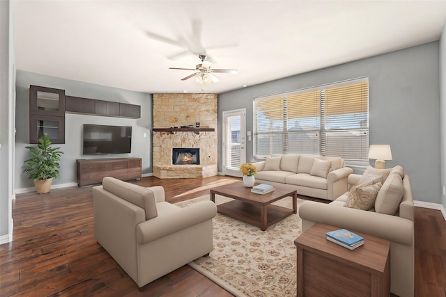 living room featuring ceiling fan, a fireplace, and dark hardwood / wood-style flooring