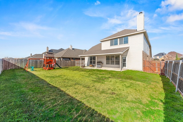 back of property with a playground, a lawn, and a patio