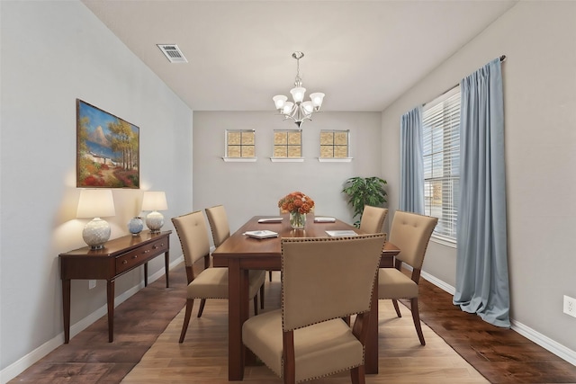 dining room featuring hardwood / wood-style flooring and an inviting chandelier