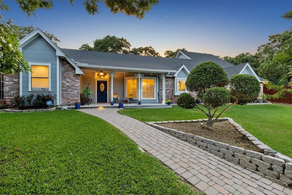 ranch-style house featuring a yard and covered porch