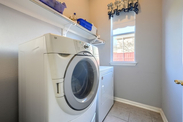 washroom featuring washing machine and dryer and light tile patterned floors