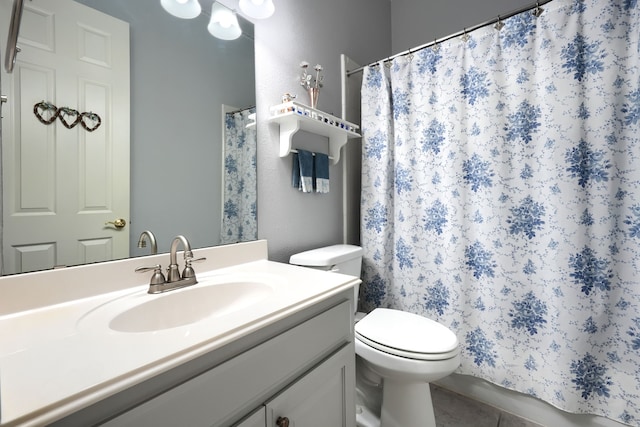 bathroom featuring tile patterned floors, vanity, and toilet