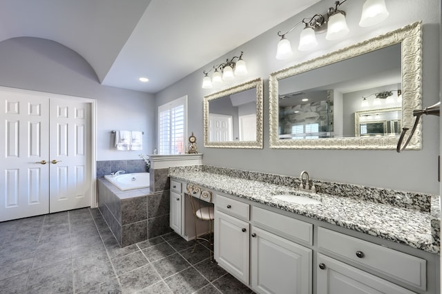 bathroom featuring vanity and tiled tub