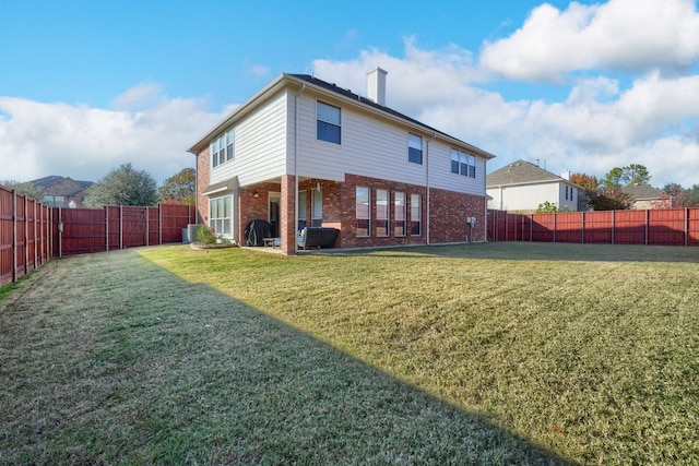 back of property with cooling unit and a lawn