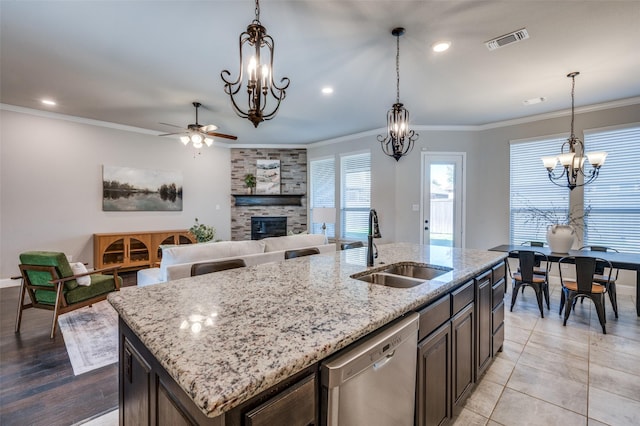 kitchen featuring a kitchen island with sink, a sink, visible vents, ornamental molding, and dishwasher