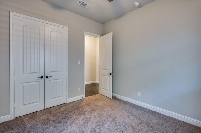 unfurnished bedroom featuring a closet, carpet flooring, visible vents, and baseboards