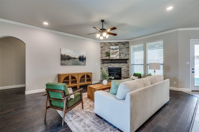 living room with arched walkways, dark wood-style flooring, crown molding, and baseboards