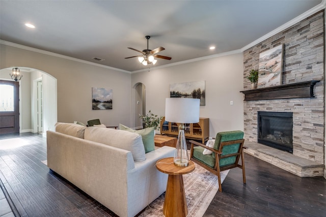 living room featuring arched walkways, dark wood-type flooring, ornamental molding, and visible vents