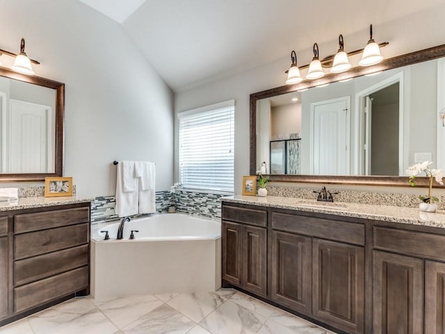 full bathroom featuring a shower stall, lofted ceiling, marble finish floor, vanity, and a garden tub