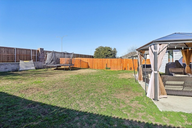 view of yard with a gazebo, a trampoline, and a patio area