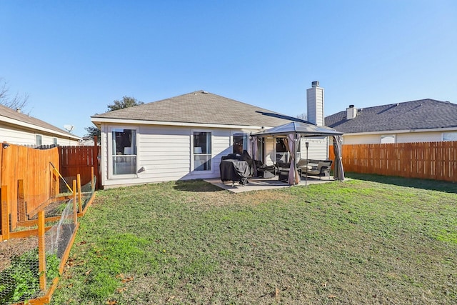 back of property with a gazebo, a patio, and a lawn