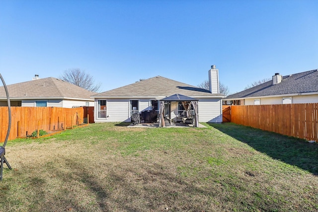 rear view of property featuring a gazebo, a patio area, and a yard