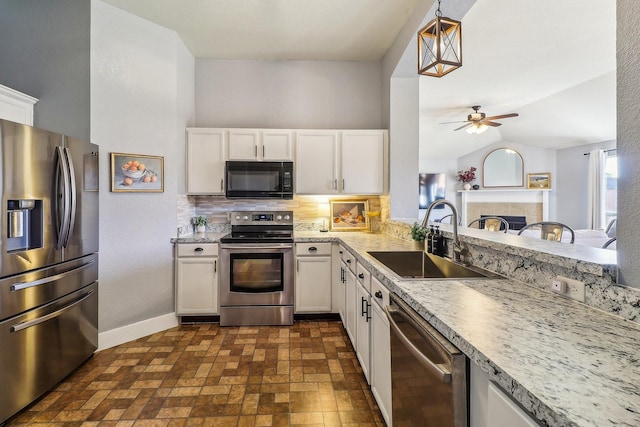 kitchen featuring white cabinets, hanging light fixtures, sink, appliances with stainless steel finishes, and tasteful backsplash