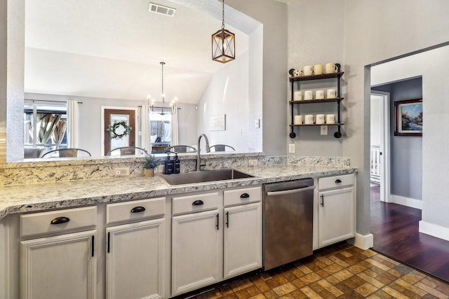 kitchen featuring vaulted ceiling, sink, pendant lighting, dishwasher, and a chandelier