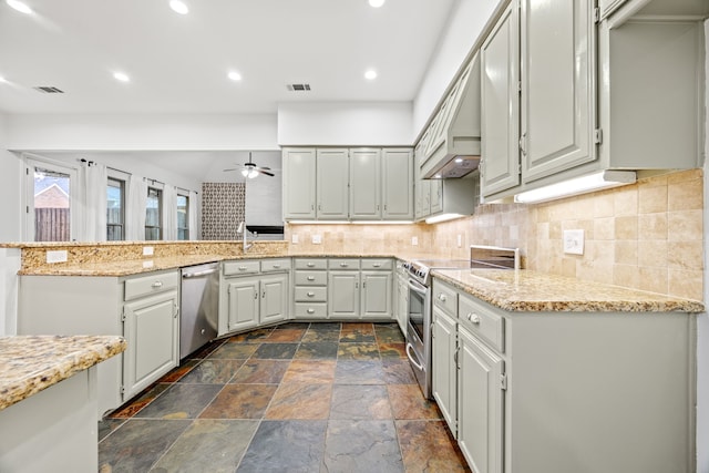 kitchen featuring a peninsula, stainless steel appliances, decorative backsplash, and recessed lighting