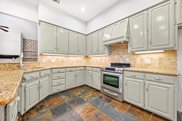 kitchen with stone tile flooring, electric stove, and backsplash