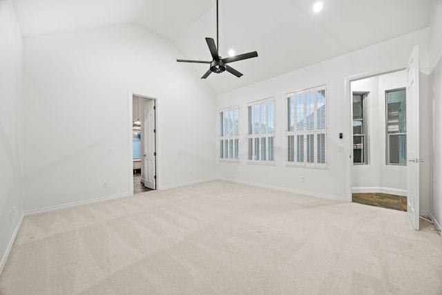 empty room with carpet floors, high vaulted ceiling, baseboards, and a ceiling fan