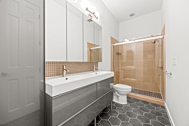 bathroom featuring a stall shower, toilet, a sink, tile patterned flooring, and backsplash