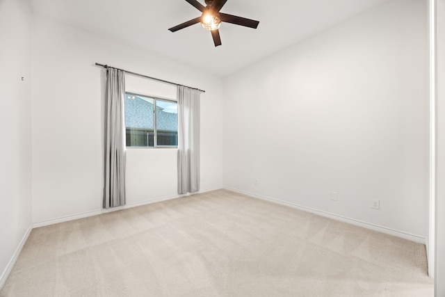 unfurnished room featuring baseboards, a ceiling fan, and light colored carpet