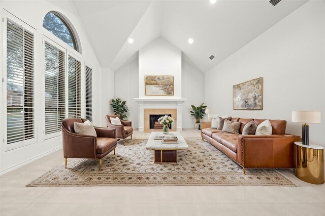 living room featuring high vaulted ceiling and a tiled fireplace