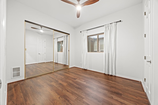 unfurnished bedroom featuring a ceiling fan, visible vents, baseboards, and wood finished floors