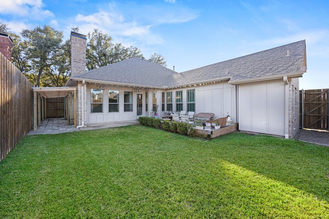 back of house with a fenced backyard, a chimney, roof with shingles, a yard, and board and batten siding