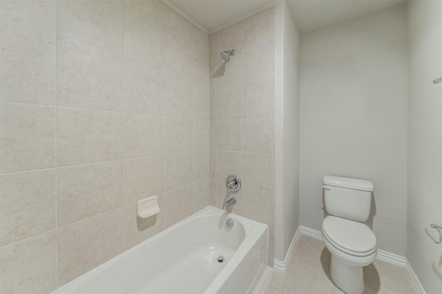 bathroom featuring tile patterned flooring, tiled shower / bath, and toilet