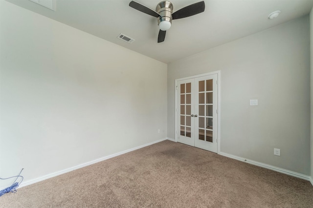 carpeted spare room with ceiling fan and french doors